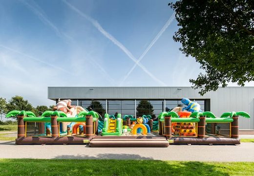 Gekleurde inflatable park in jungle thema met glijbanen, 3D objecten, kruiptunnel en klimtoren bestellen voor kinderen. Koop springkastelen online bij JB Inflatables Nederland 