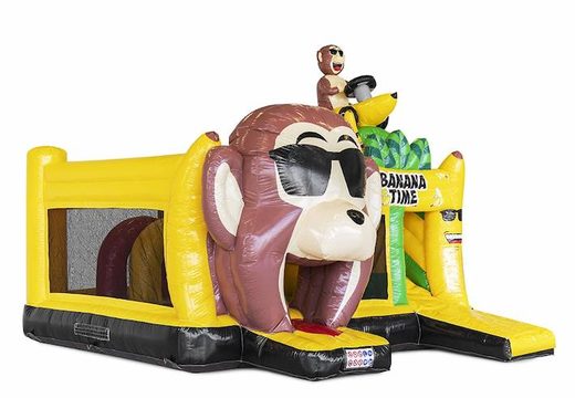 Opblaasbaar springkasteel met obstakels erin en een glijbaan in bananen apen thema bestellen