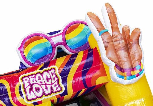 Opblaasbaar springkasteel met glijbaan in hippie thema met veel kleuren bestellen voor kinderen